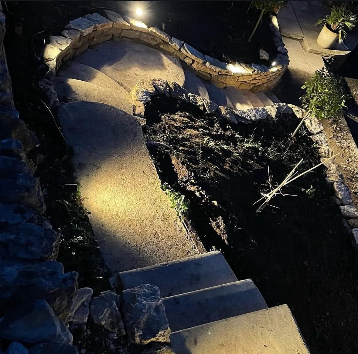 Dry-stone garden walls and steps picked out with warm recessed lighting at night