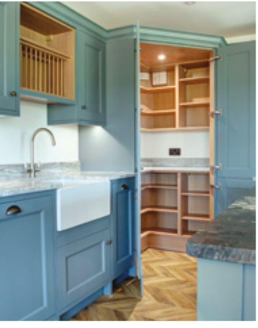 Blue shaker kitchen and lit walk-in pantry with a Belfast sink