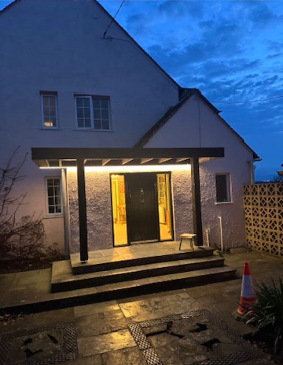 Front porch canopy with concealed warm LED strip lighting at dusk