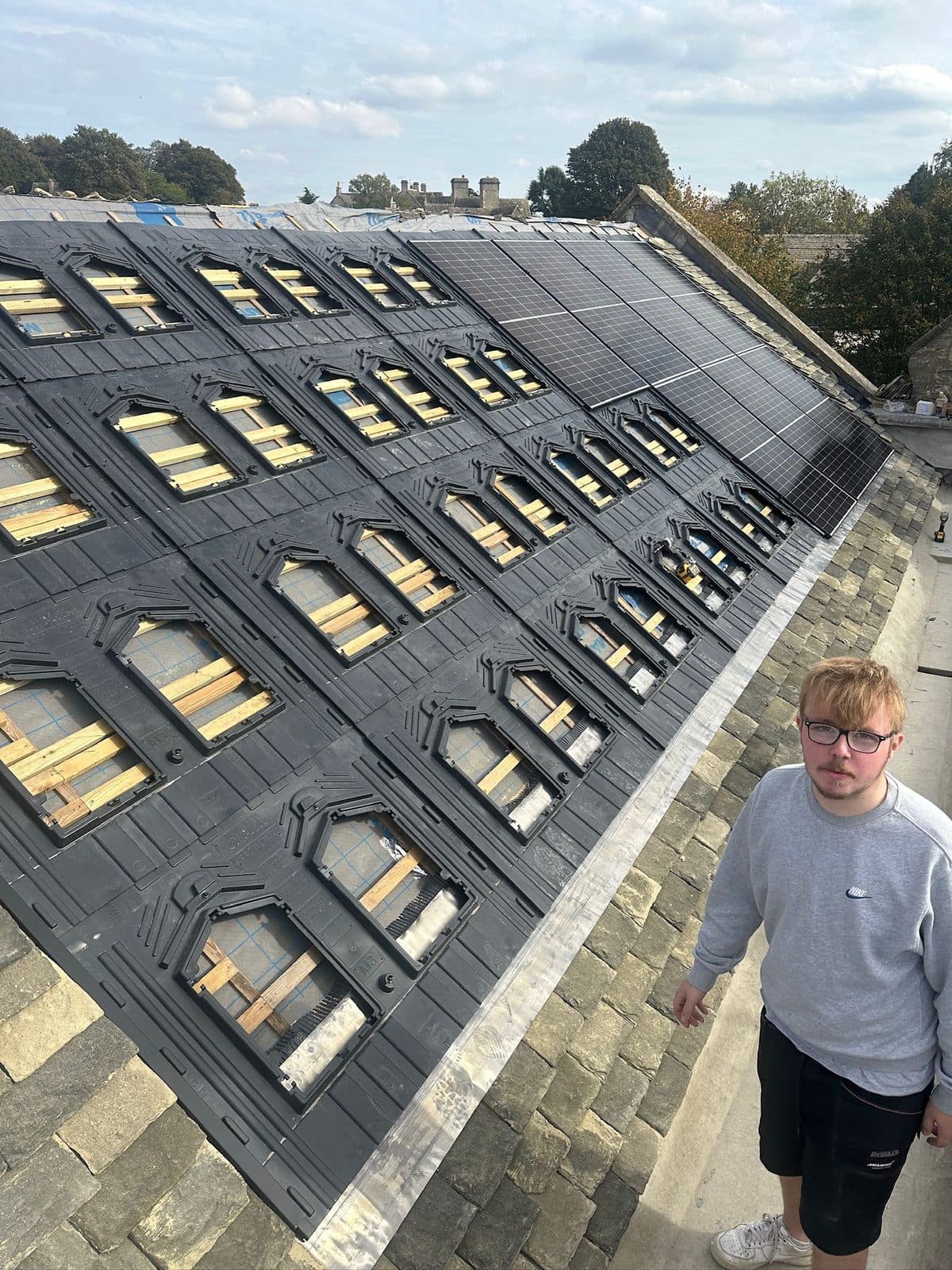 Solar PV panels being installed on a slate roof with integrated in-roof mounting